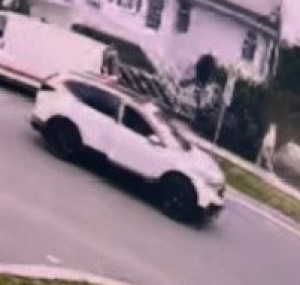 Surveillance image of a white SUV on the road